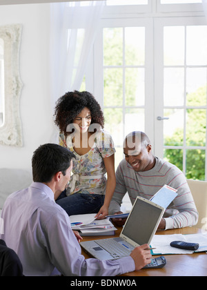 Young African American couple discutant accueil finances avec conseiller financier à table de salle à manger Banque D'Images