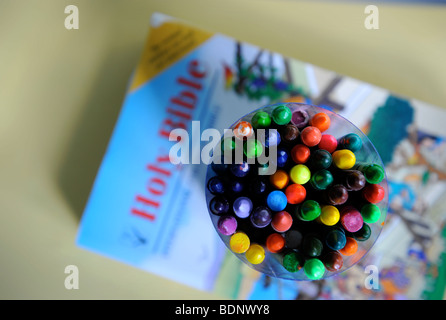 Une COLLECTION DE CRAYONS DE COULEUR AVEC LA SAINTE BIBLE POUR ENFANTS À UNE ÉCOLE DU DIMANCHE UK Banque D'Images
