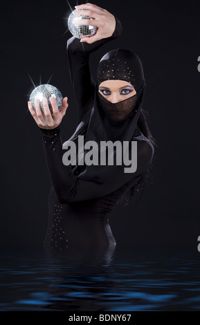 Partie danseur dans ninja dress avec boules disco Banque D'Images
