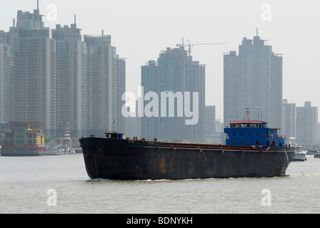 Freighter, barge de transport sur la rivière Huangpu en face de Chinois des immeubles de grande hauteur, Shanghai, Chine, Asie Banque D'Images