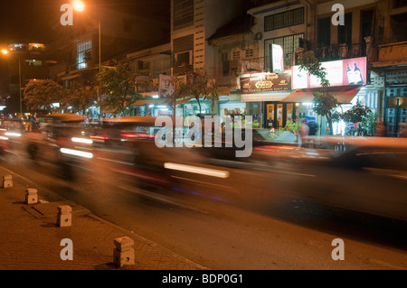 Rue de la rivière dans la nuit, le motion blur montrant les tuk-tuks et autres la vie de la rue. Phnom Penh, Cambodge, Asie du sud-est. Banque D'Images