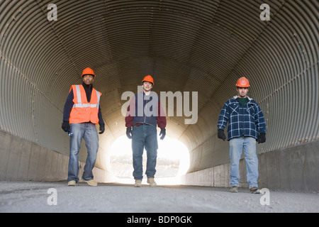 Trois ingénieurs de marcher dans un tunnel Banque D'Images