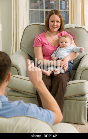 La signature de l'homme mot 'besoin' dans la langue des signes américaine lors de la communication avec une femme Banque D'Images