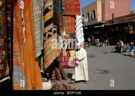 L'arabe musulman marocain Homme portant un tapis dans la Jellaba Bazar, Souk ou marché, Marrakech, Maroc Banque D'Images