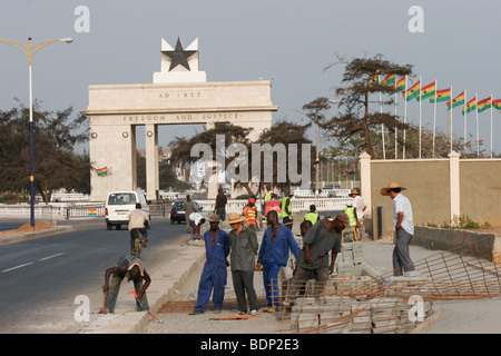 Les travailleurs de la route conduit par le contremaître chinois réparer le trottoir près de la place de l'indépendance et à l'Étoile noire monument. Accra. Le Ghana. Banque D'Images