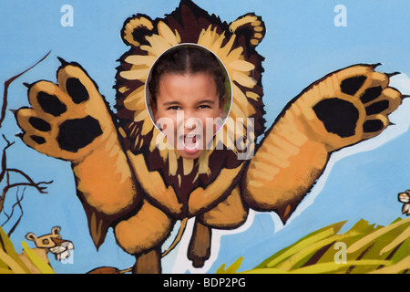 Une petite fille avec sa tête dans un lion rugissant et affichage Banque D'Images