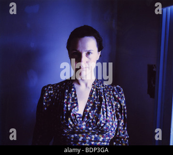 Une femme d'âge moyen portant une robe bleue à la recherche à l'appareil photo Banque D'Images