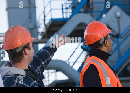 Deux ingénieurs discuter à une usine d'asphalte, Banque D'Images