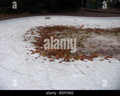 Piscine vide dans le nord de Londres avec des feuilles marron Banque D'Images