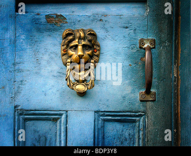 Un heurtoir en laiton sur une porte bleue en forme de lions head Banque D'Images