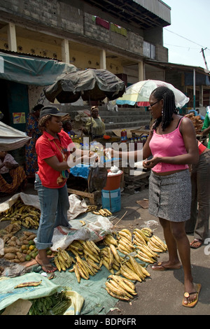 Marché de rue dans quartier pauvre de Grand Moulin Douala Cameroun Afrique de l'Ouest avec des stands vendant de l'huile de cuisson de l'igname plantain Banque D'Images