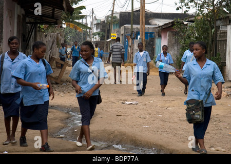 Les jeunes filles du secondaire et les garçons en uniforme à l'école au quartier pauvre de Grand Moulin Douala Cameroun Afrique de l'Ouest Banque D'Images