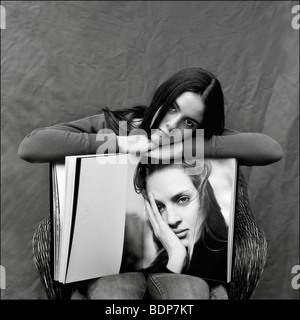 Une jeune femme assise sur le bord d'un grand livre Banque D'Images