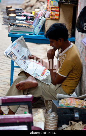 Reading newspaper in Calcutta Inde Banque D'Images