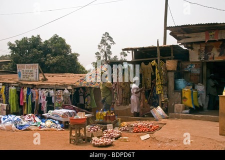 Scène de rue avec des boutiques et étals de vente de tissus de vêtements de l'huile de cuisson des légumes et des denrées alimentaires Yaoundé, Cameroun l'Afrique de l'Ouest Banque D'Images