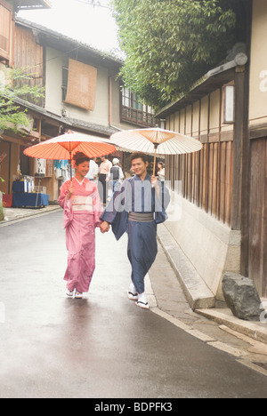 Jeune couple en kimono walking Down Hill Banque D'Images