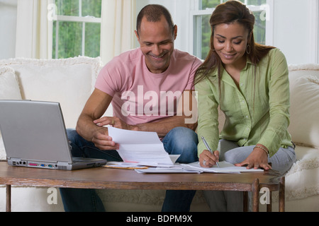 Hispanic couple faire le tri des factures Banque D'Images
