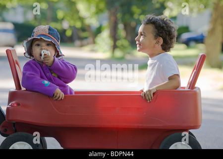 Deux enfants hispaniques dans un chariot Banque D'Images