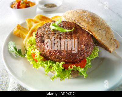 Burger de boeuf dans un petit pain de blé entier avec salade et frites Banque D'Images