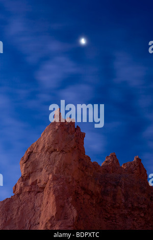 Demi Lune ensembles lentement sur rouge-rock spires à l'aube à Bryce Canyon National Park, Utah, USA. Banque D'Images