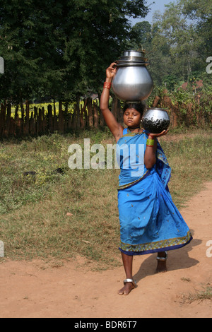 Portrait de femme indienne de la tribu Dhuruba transportant un grand pot d'eau sur la tête. Banque D'Images