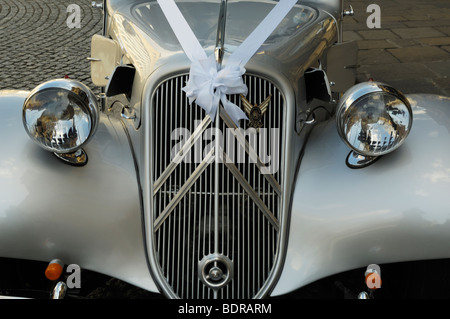L'avant d'un argent entièrement restauré Citroen Traction Avant Légère utilisée comme voiture de mariage avec ruban blanc. Banque D'Images