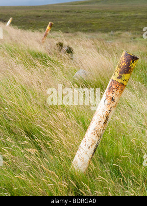 Une ligne de poteaux métalliques dans l'herbe par la route, près de Sally Gap dans les montagnes de Wicklow Irlande UE Banque D'Images