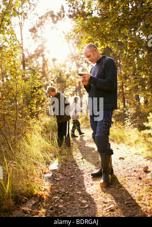 Homme et deux enfants dans la forêt Banque D'Images