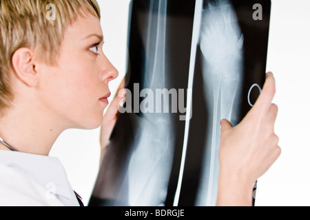 Une femme médecin tenant une plaque de rayons X Banque D'Images