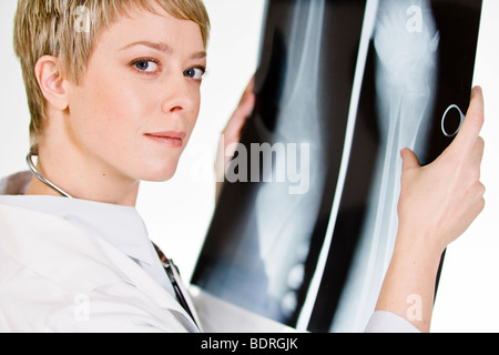 Une femme médecin tenant une plaque de rayons X Banque D'Images