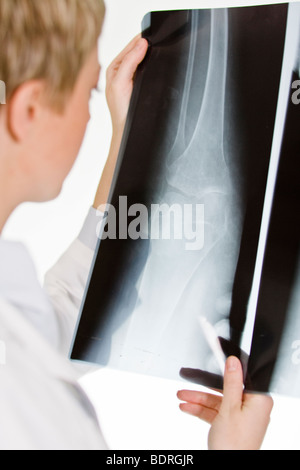 Une femme médecin tenant une plaque de rayons X Banque D'Images