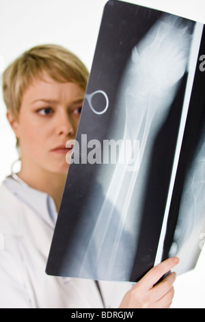 Une femme médecin tenant une plaque de rayons X Banque D'Images