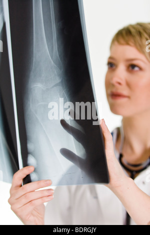 Une femme médecin tenant une plaque de rayons X Banque D'Images