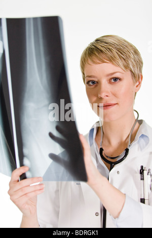 Une femme médecin tenant une plaque de rayons X Banque D'Images