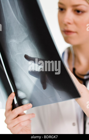 Une femme médecin tenant une plaque de rayons X Banque D'Images