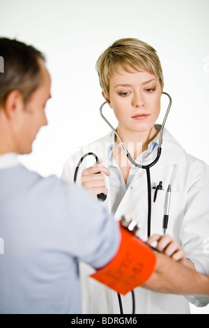 Une femme médecin à l'aide d'une jauge de pression artérielle Banque D'Images