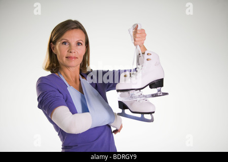 Une femme blessée holding patins. Banque D'Images