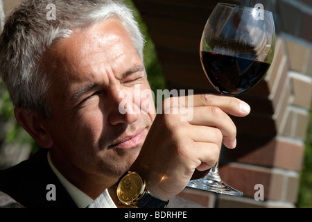 Portrait d'un homme en observant la couleur du vin Banque D'Images