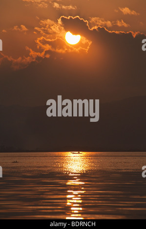 Coucher du soleil doré à travers les nuages sur le lac Inle, l'État de Shan, Myanmar, Birmanie, en Asie du sud-est Banque D'Images