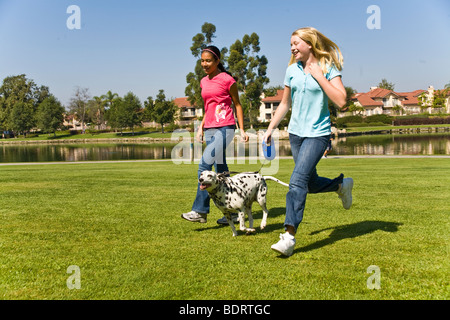 Propriétaire de chien à 13 ans ans d'exécution multiples la diversité multiculturelle mélange caucasien hispanique d'interpolations de Tween sain boutonneuses vue latérale avant USA © Myrleen Pearson Banque D'Images