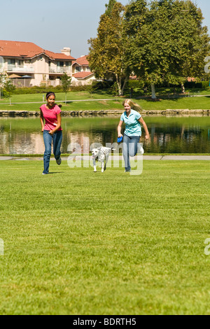 Deux filles accrocher à traîner ensemble et hispanique d'interpolations de Tween Caucase femelle divers filles courir avec un dalmatien USA/MR © Myrleen Pearson Banque D'Images