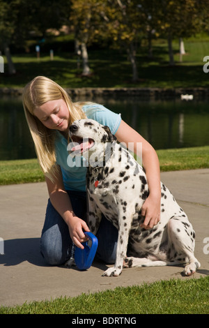 Hugging dog enfant 11-13 ans ans bras autour de hug hugging chien Dalmatien propriétaire montrer de l'affection avant voir le profil MR © Myrleen Pearson Banque D'Images