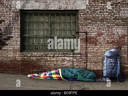 L'âme sans-abri dormant dans les rues dans un sac de couchage à l'extérieur Banque D'Images