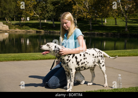 Portrait de profil Vue de côté l'âge junior fille 11-13 ans ans et propriétaire de chien dalmatien repéré des taches éparses montrer de l'affection Monsieur © Myrleen Pearson Banque D'Images