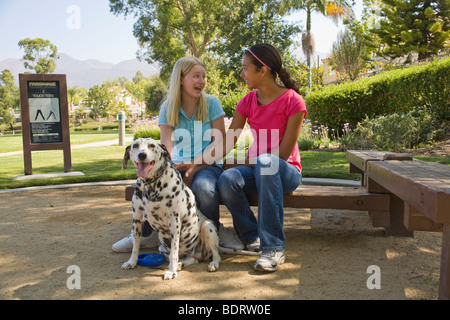 Hispanic and Caucasian middle school ethniques divers tweens Tween girls sitting et parler en parc. Vue avant M. © Myrleen Pearson Banque D'Images