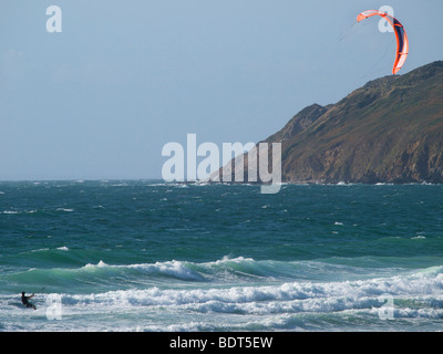 Kitesurfer Riding the Waves à Les Pieux, Normandie, France avec grande falaise à l'arrière-plan Banque D'Images