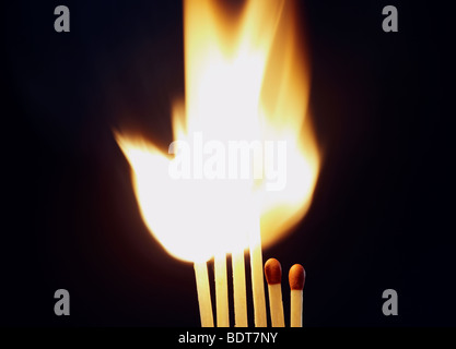 Flamme lumineuse que quatre matches sont mis le feu alors que deux plus petits rester éteinte Banque D'Images
