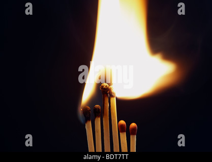 Flamme lumineuse que quatre matches sont mis le feu alors que deux plus petits rester éteinte Banque D'Images