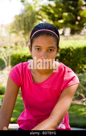Haut junior fille hispanique age pensée pensées graves et à la caméra en pensée réfléchie rêver assis.MR © Myrleen Pearson Banque D'Images