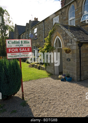 Construit en pierre avec un cottage village country estate agents For Sale sign Banque D'Images